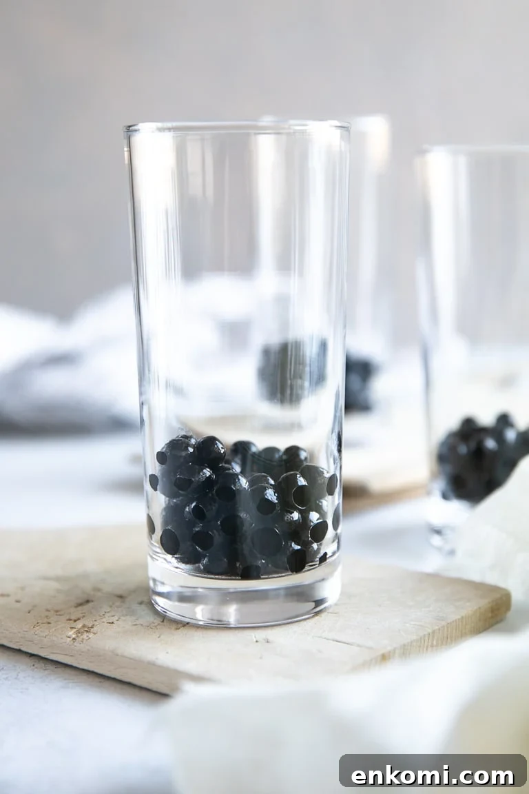 How to Make Authentic Bubble Tea at Home: Tapioca Pearl Recipe 6 A close up of a glass cup on a counter with tapioca pearls (boba)
