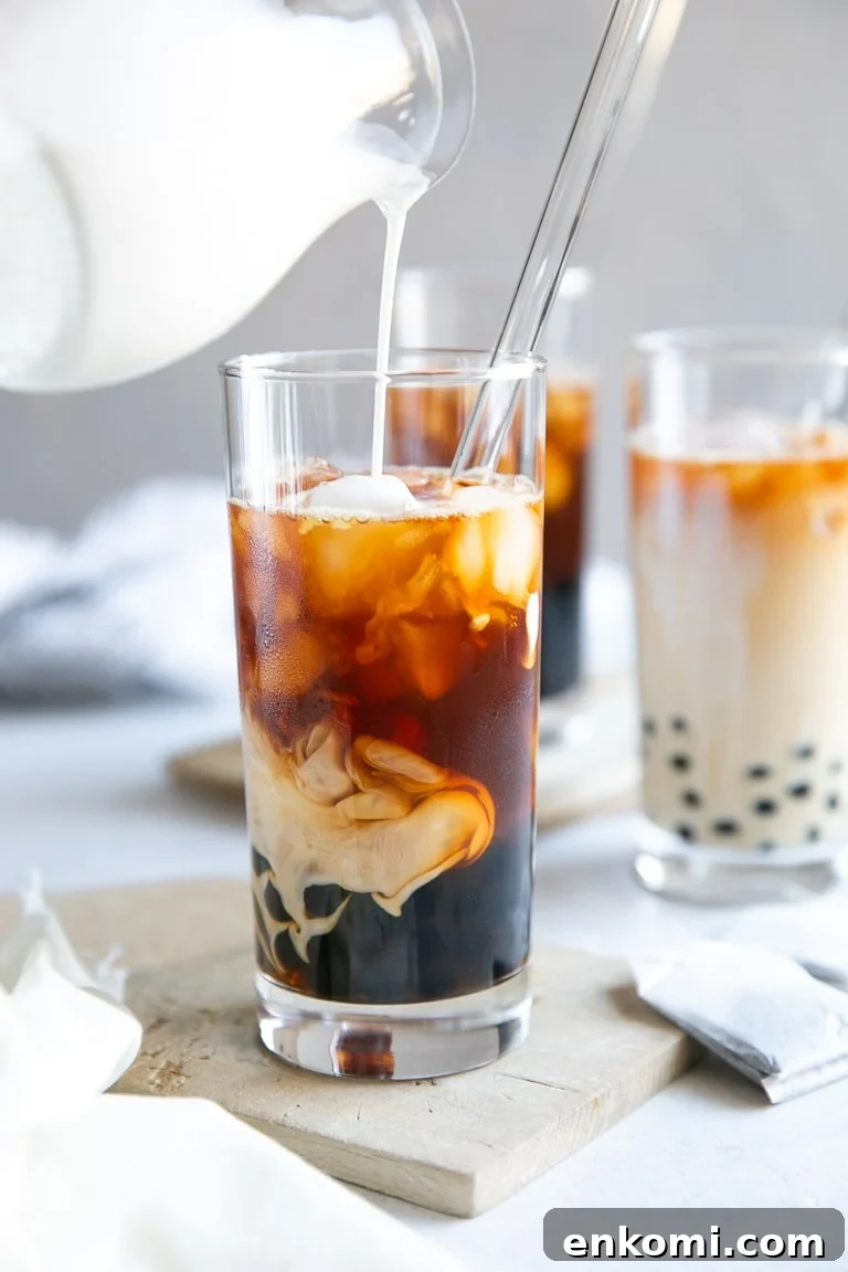 How to Make Authentic Bubble Tea at Home: Tapioca Pearl Recipe 8 Milk being poured into a glass of bubble tea.