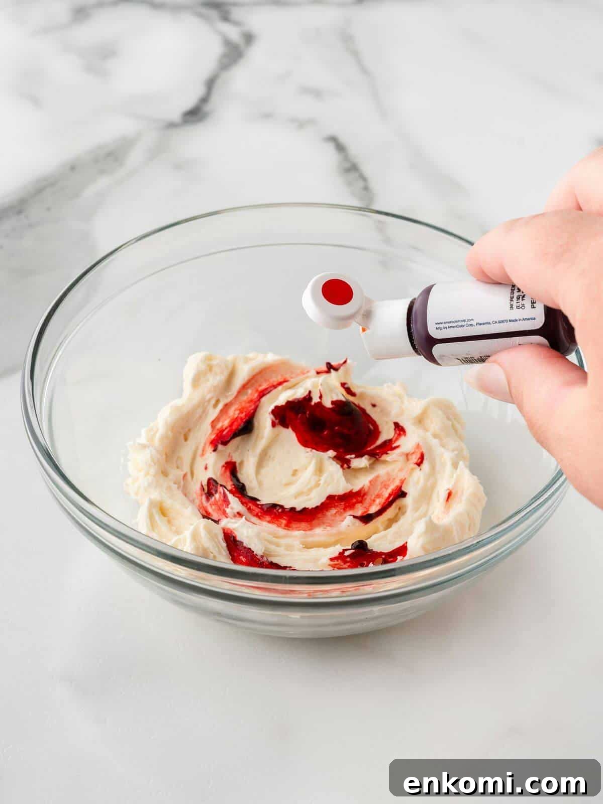 Baseball-Themed Sugar Cookies: Recipes and Decorating Tips 11 adding red food dye to white frosting in small glass bowl