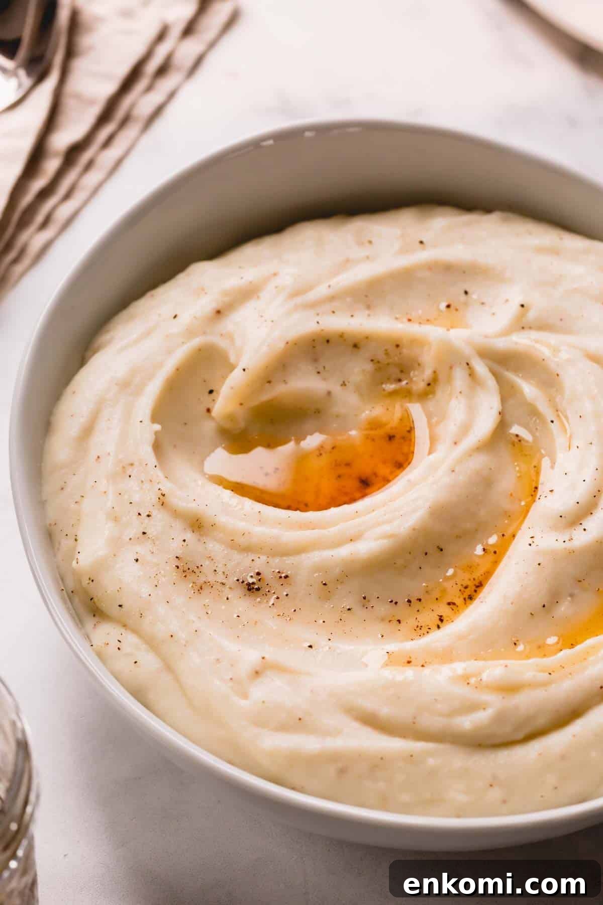 A bowl of brown butter mashed potatoes topped with brown butter and black pepper.