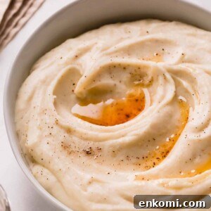 A bowl of brown butter mashed potatoes topped with brown butter and black pepper.