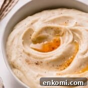 A bowl of brown butter mashed potatoes topped with brown butter and black pepper.