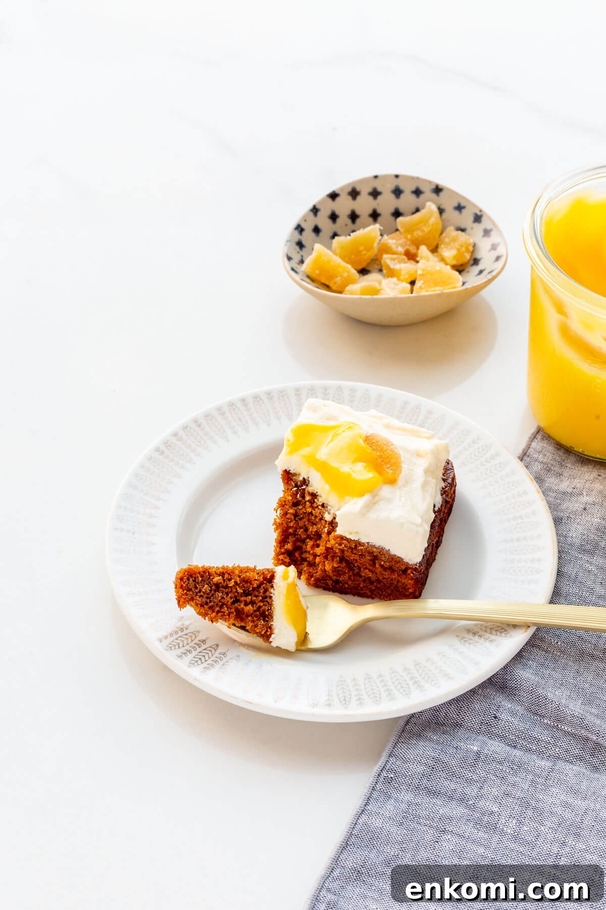 A square of gingerbread cake topped with cream cheese frosting and lemon curd.