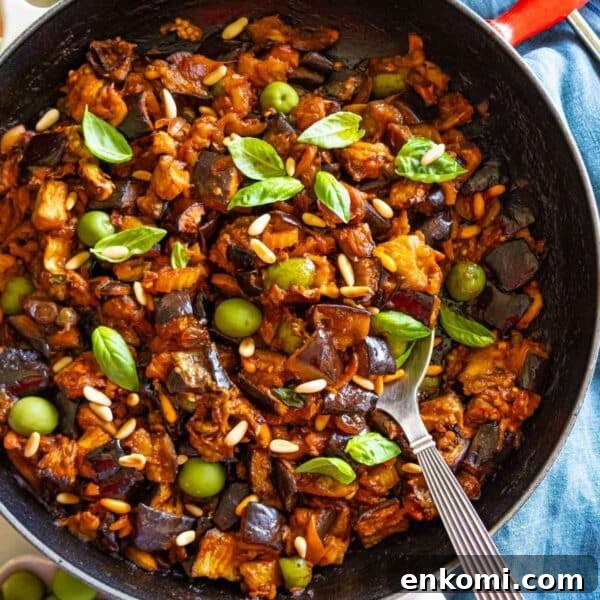 Authentic Sicilian caponata recipe styled in a skillet with a spoon, perfect as a Mediterranean side or plant-based appetizer.