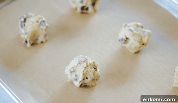 Chocolate chip cookie dough balls on baking sheet.