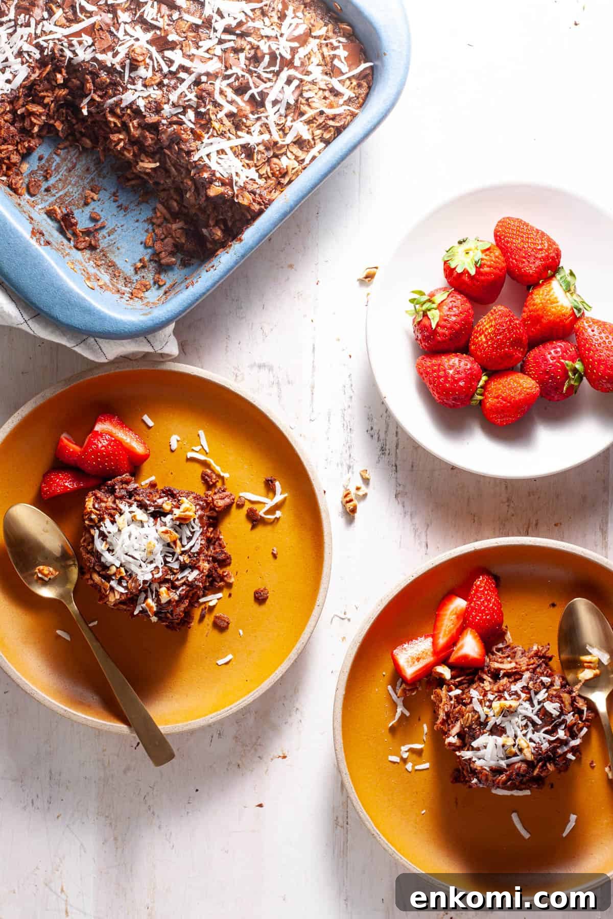 German Chocolate Cake Baked Oatmeal Recipe for Decadent Mornings 9 German chocolate baked oatmeal on a couple small plates with strawberries on the side.