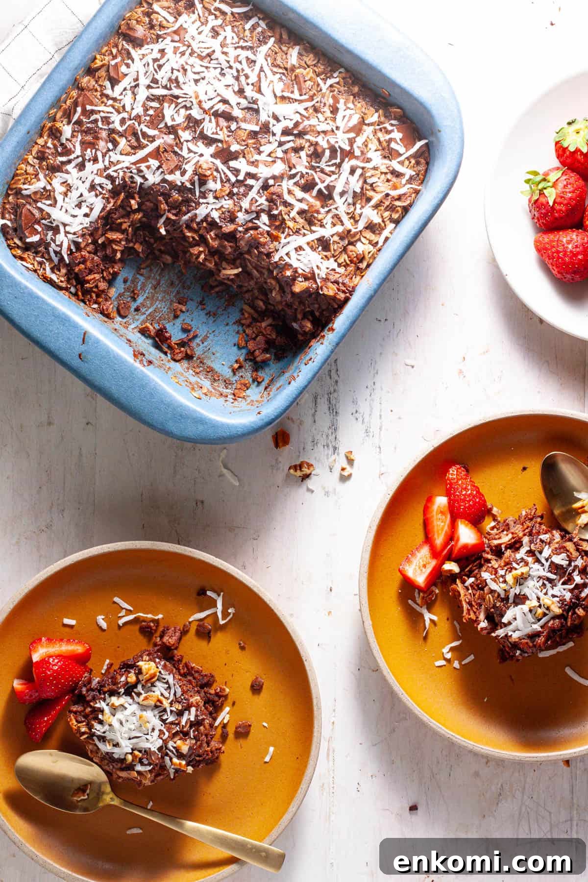 German Chocolate Cake Baked Oatmeal Recipe for Decadent Mornings 10 German chocolate baked oatmeal on a couple small plates with strawberries on the side.