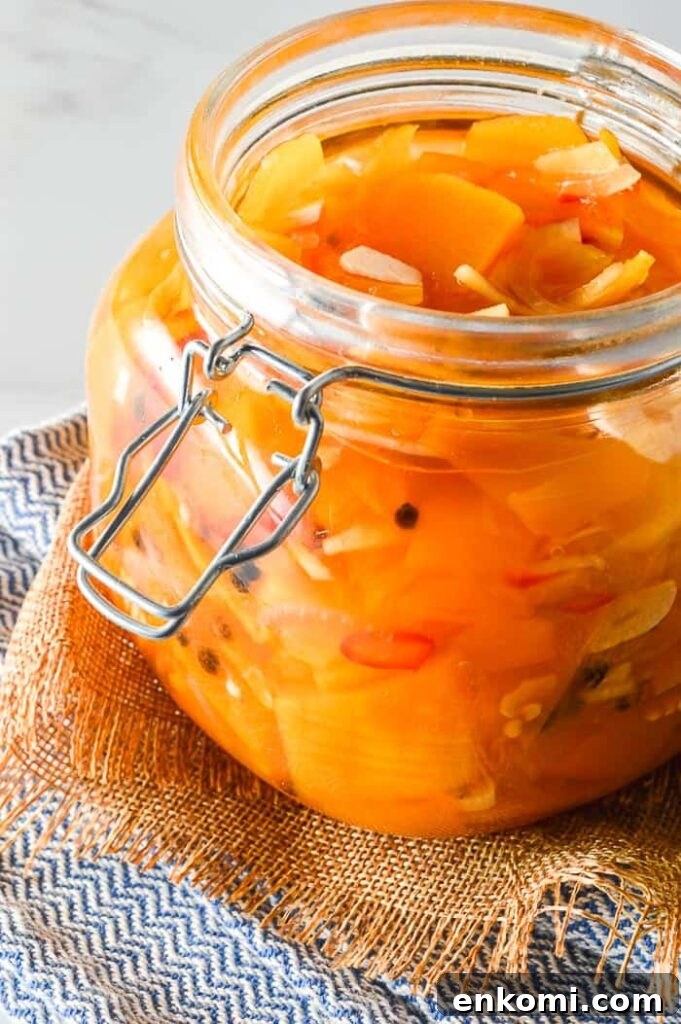Front view of sliced pumpkin and garlic and red chilis in a glass jar