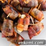 Bacon-Wrapped Dates Stuffed with Goat Cheese and Honey 6 A photo of 3-ingredient bacon wrapped dates with goat cheese with toothpicks inserted in the center on a platter.