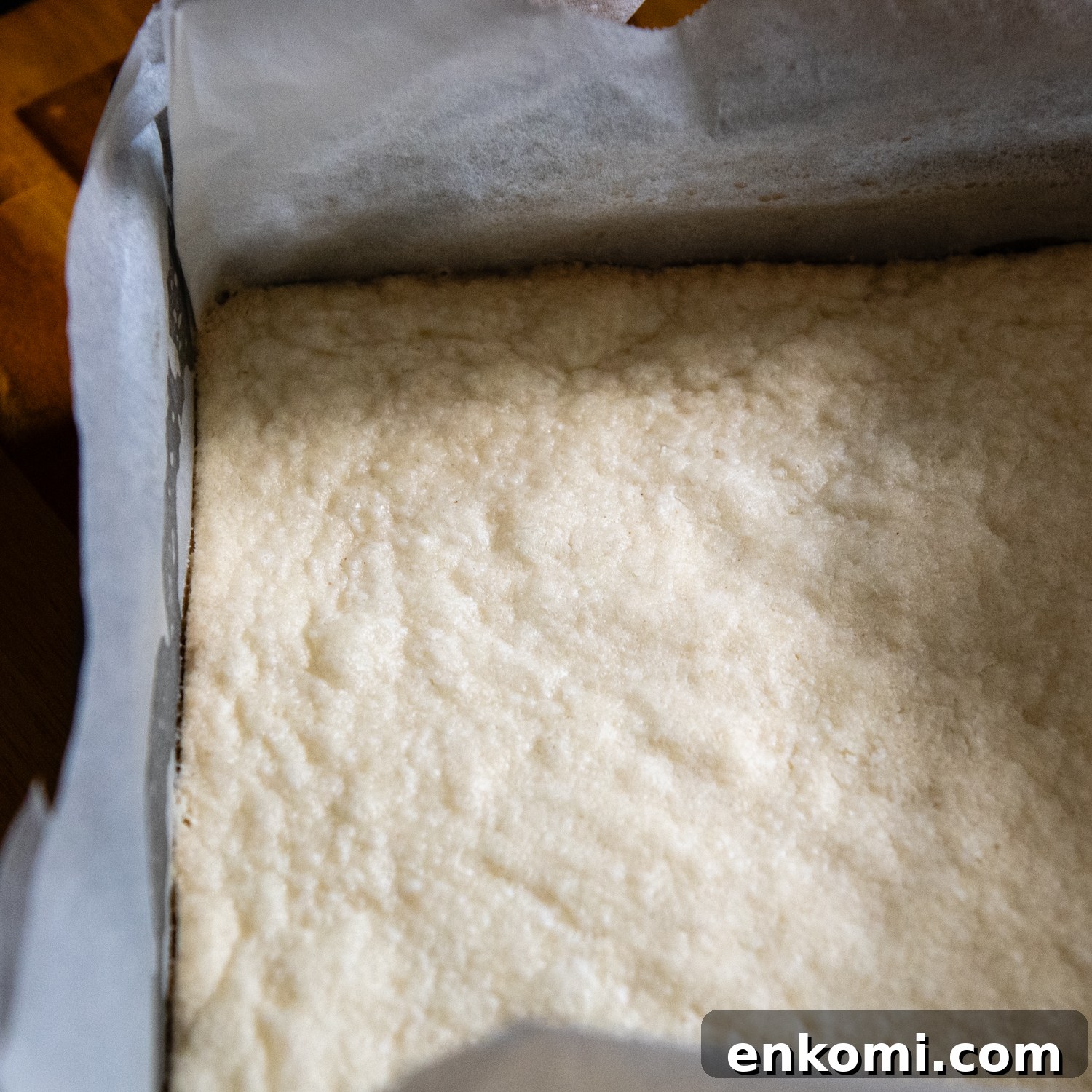 Maple Pecan Pie Bars (Gluten-Free) 5 Baked dough in parchment paper in a pan.