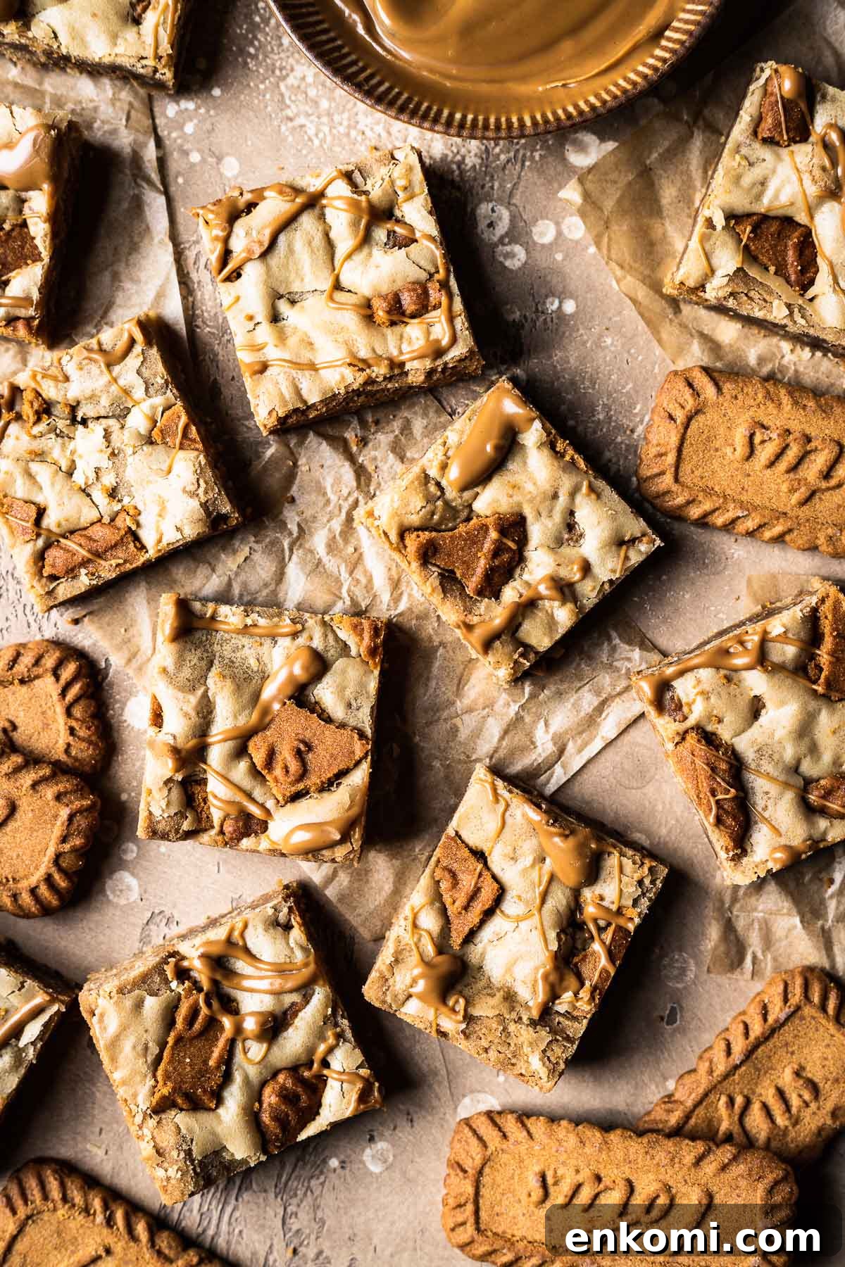 Biscoff Blondie Bars with Cookie Butter Swirl 2 Lotus biscoff blondie squares on brown parchment paper.