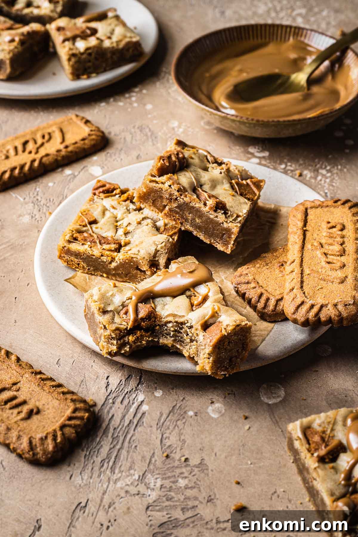 Biscoff Blondie Bars with Cookie Butter Swirl 12 A stack of biscoff blondies on a plate with a bite missing from one bar.