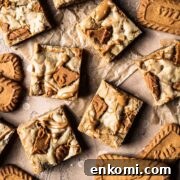 Biscoff Blondie Bars with Cookie Butter Swirl 13 Cookie butter squares on brown parchment paper.