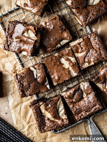 Brownie blondie squares casually arranged on a cooling rack with brown parchment underneath.