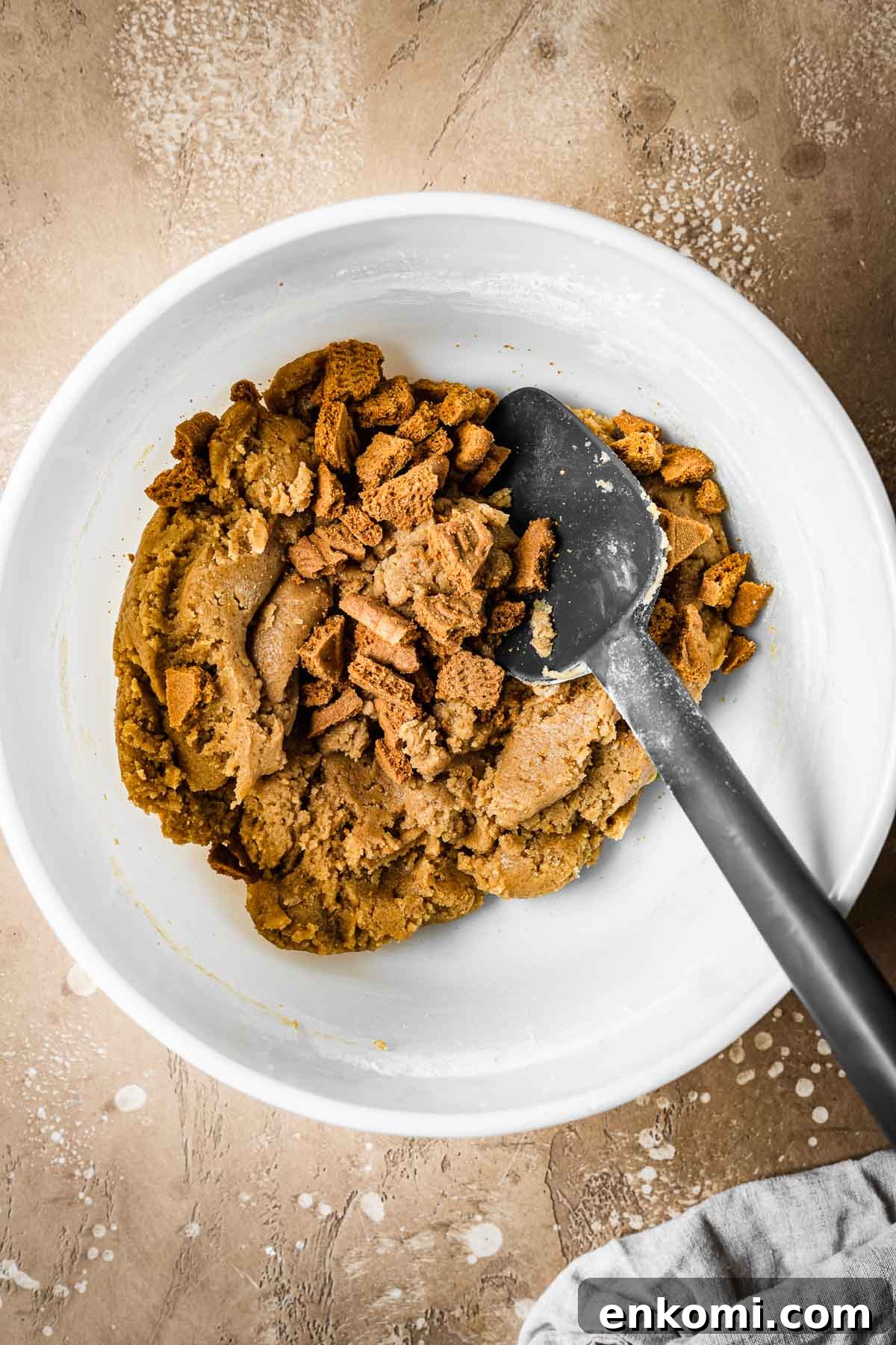 Biscoff Blondie Bars with Cookie Butter Swirl 7 Broken up biscoff cookies in dough in a mixing bowl.