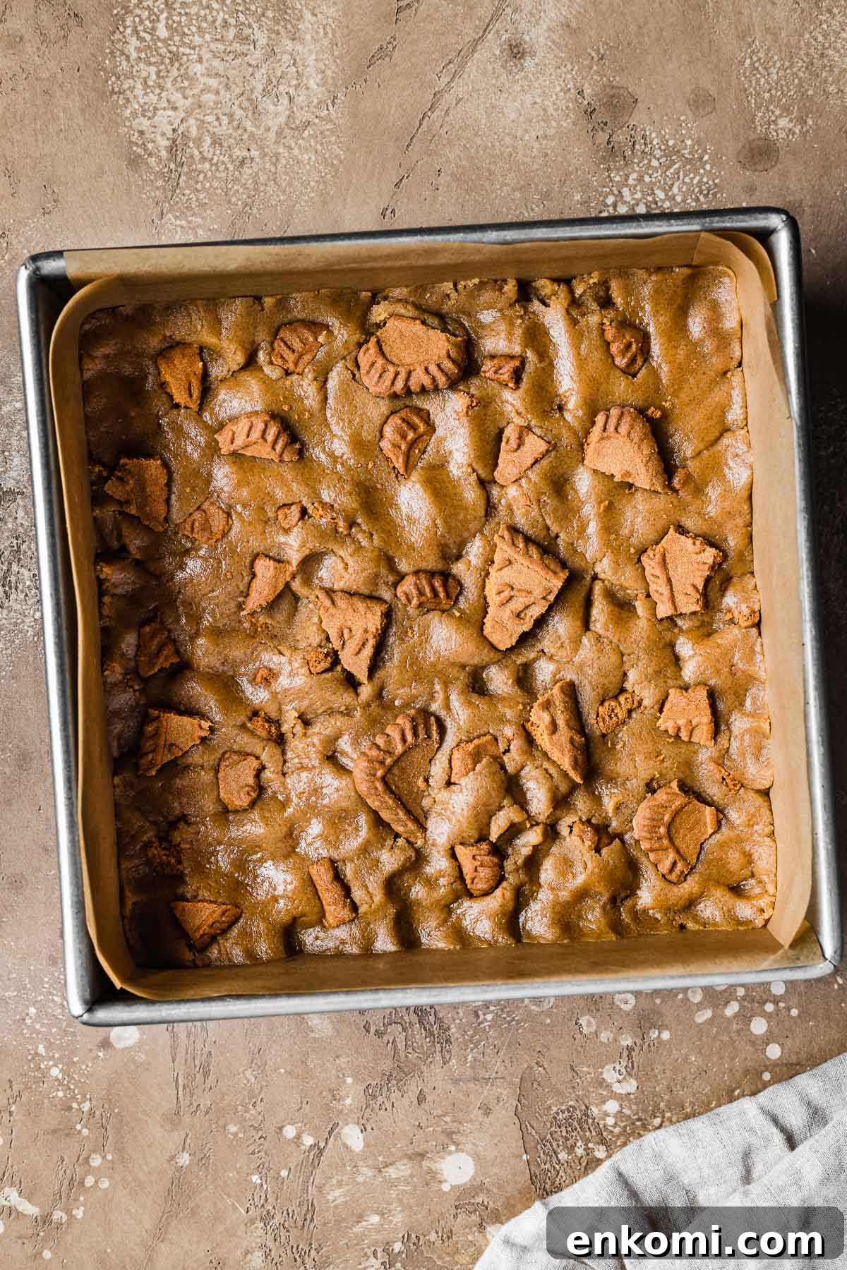 Biscoff Blondie Bars with Cookie Butter Swirl 9 Dough for bar cookies patted into a parchment lined square baking pan.