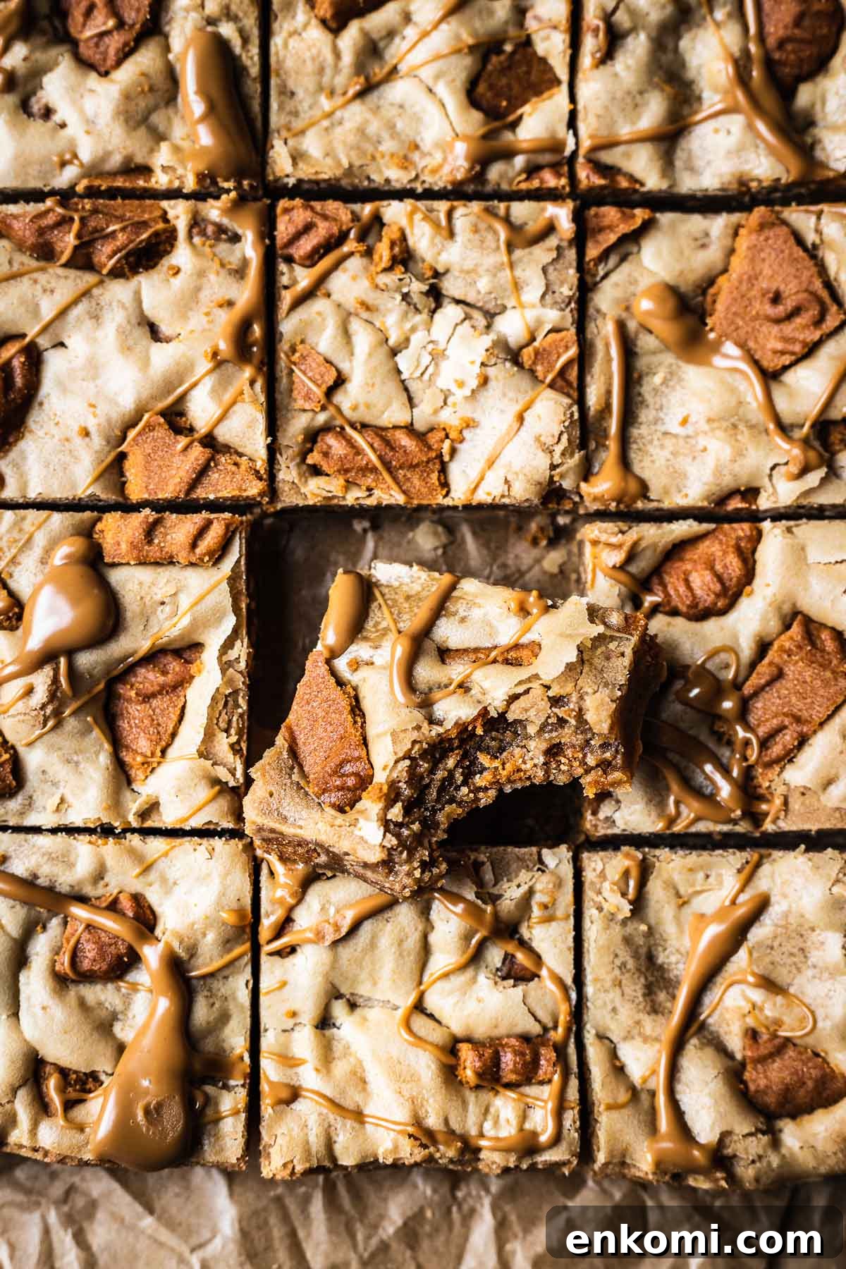 Biscoff Blondie Bars with Cookie Butter Swirl 10 A pan of sliced blondies with one square turned on an angle to show the chewy center.