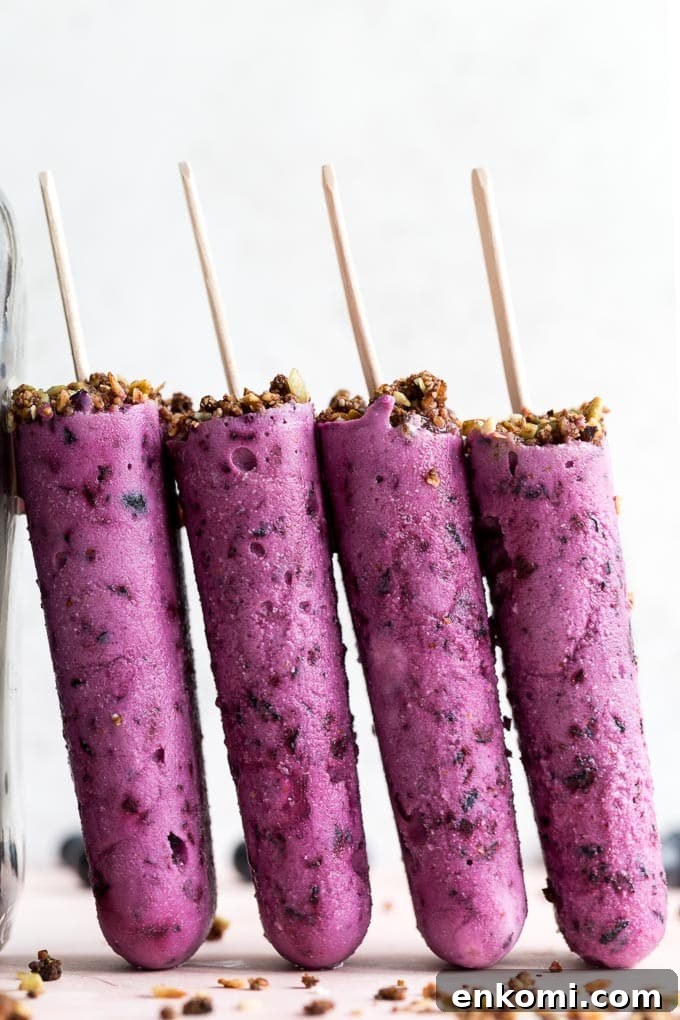 Up-close side view of blueberry goat cheese bars standing up against a jar.