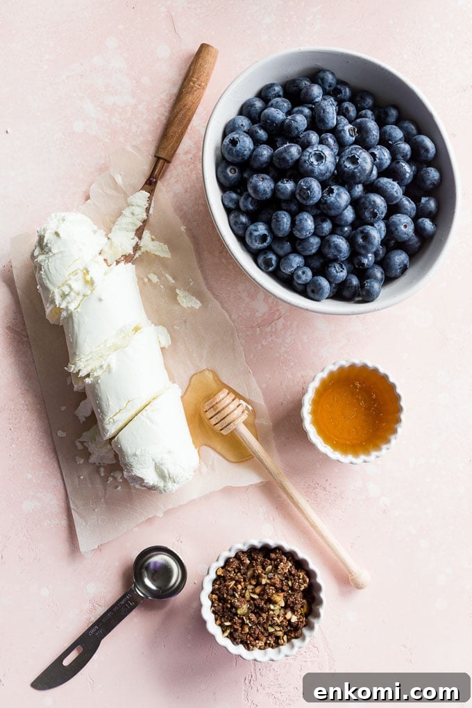 Overhead view of ingredients to make blueberry goat cheese bars arranged on a pink surface.