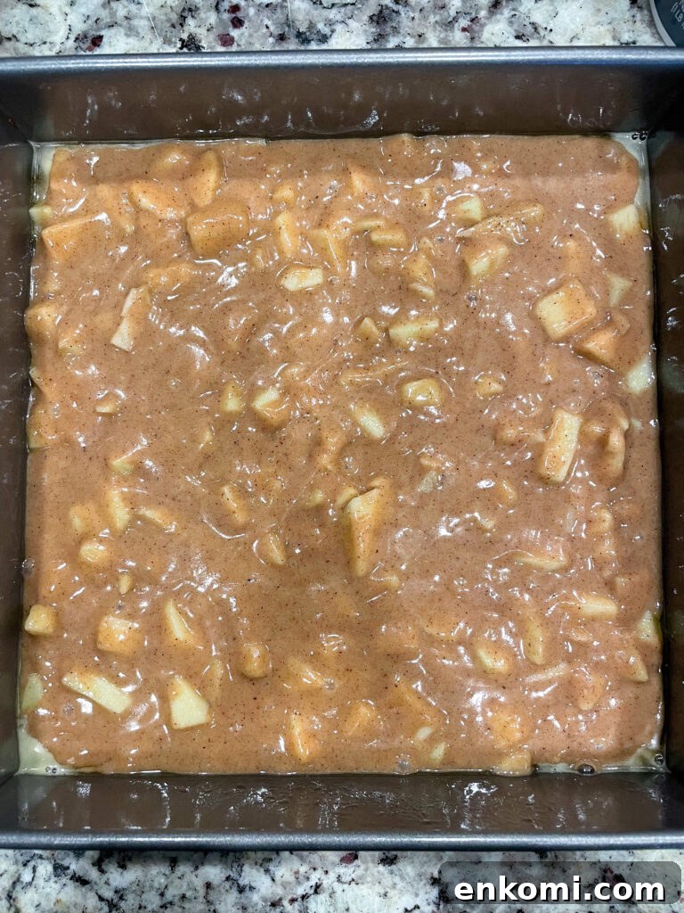 apple crumb cake batter in pan before baking.