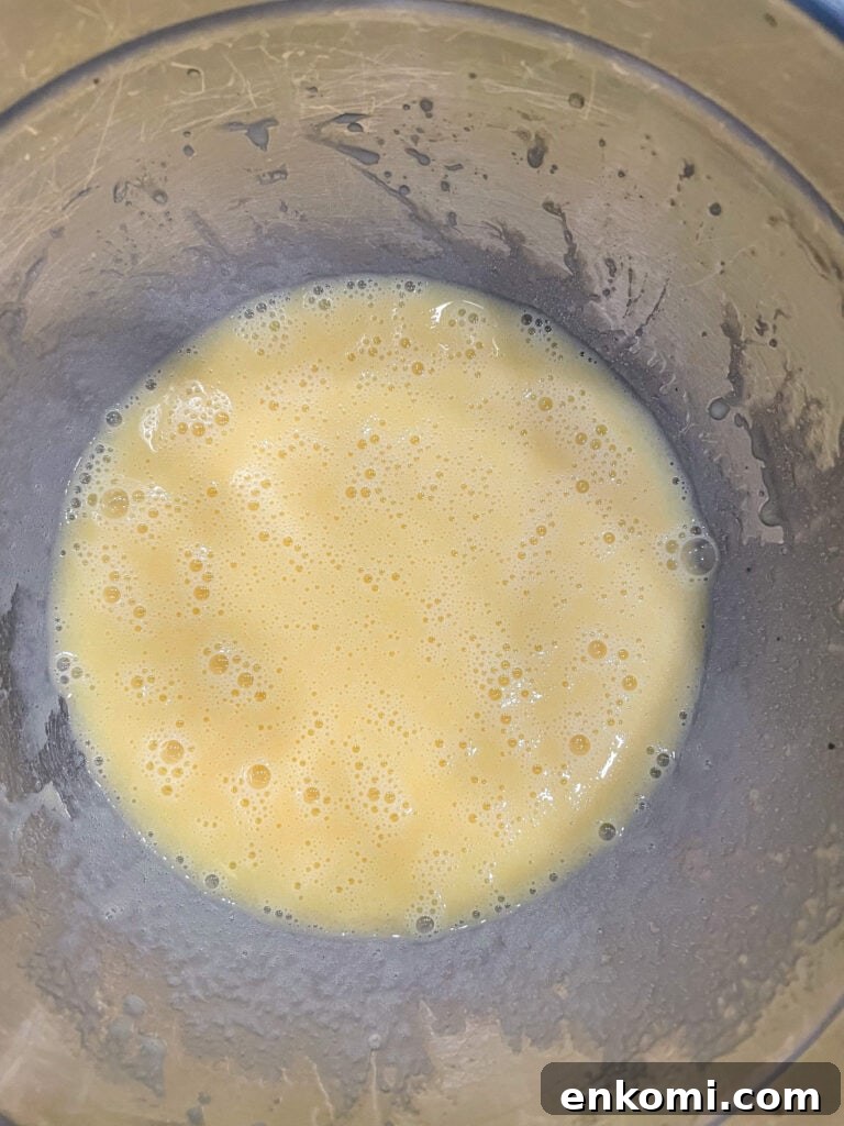 overhead shot of egg mixture for cake batter in a mixing bowl.