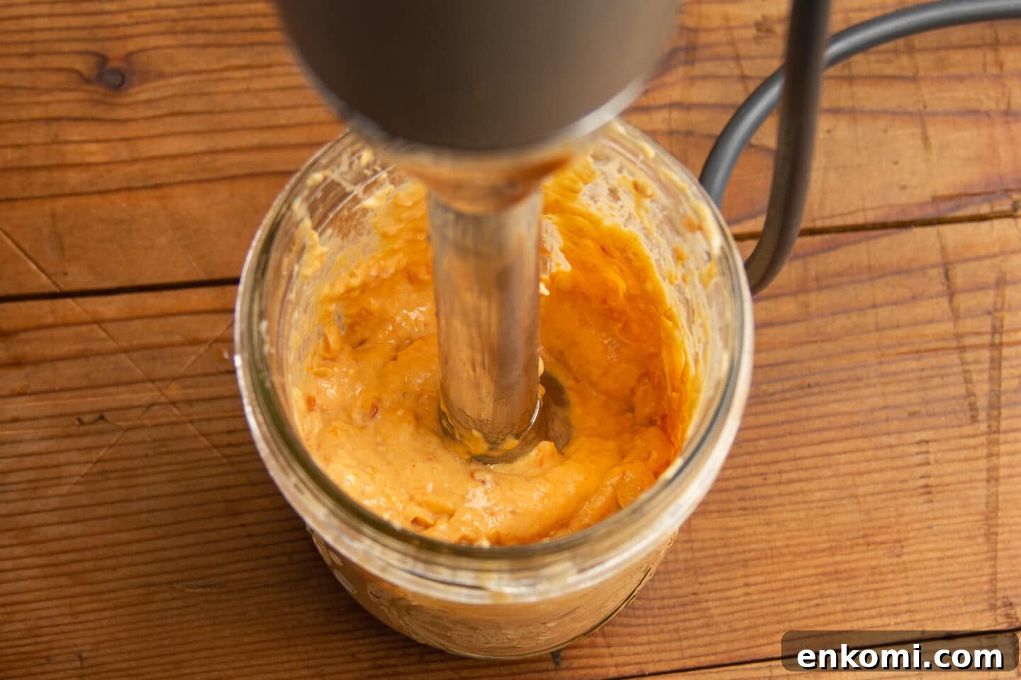 This is a picture of the aioli being blended with an immersion blender.