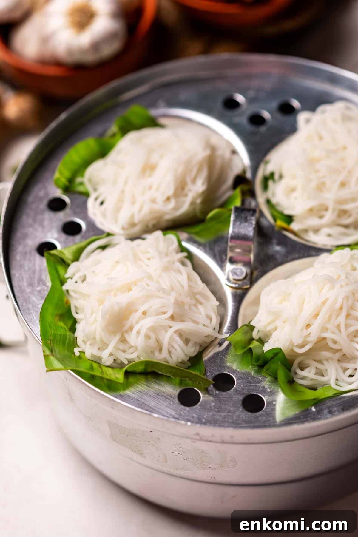 Rice Idiyappam pictured in a steamer over banana leaf