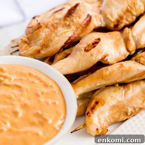 Grilled Chicken Skewers next to a bowl of dipping sauce