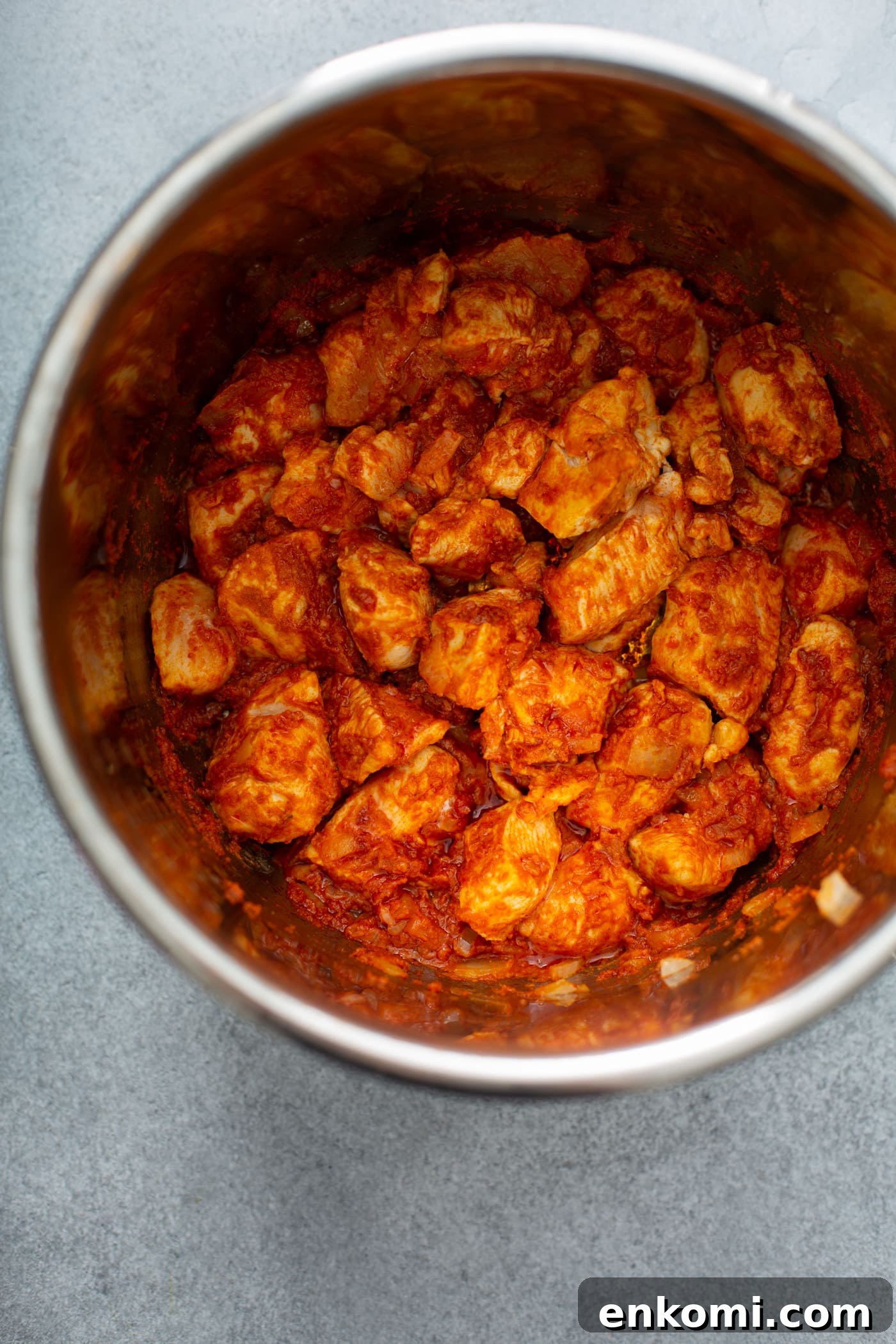 An instant pot with cubed chicken, carrots, and potatoes in a curry sauce.