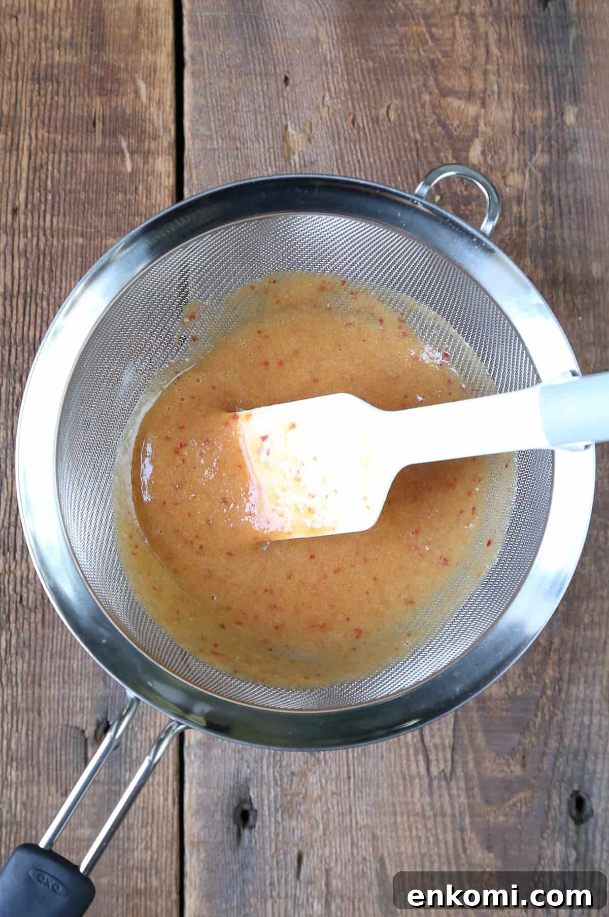 peach and apricot puree in a colander.