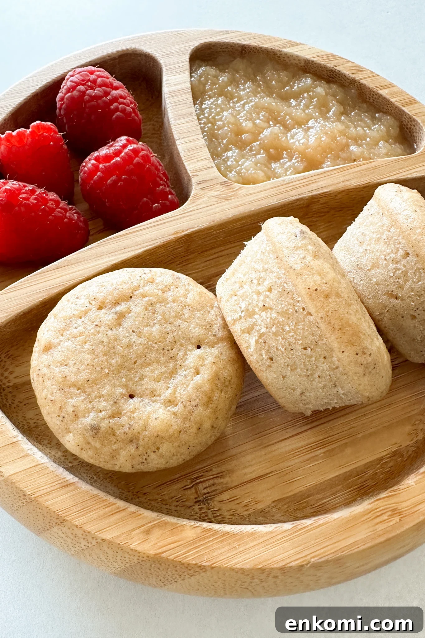 Apple donut muffins served with raspberries and applesauce.