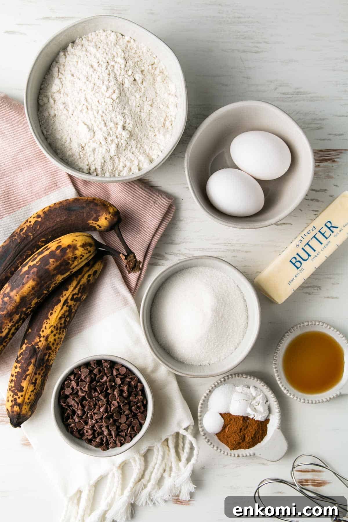 Ingredients for gluten-free chocolate chip banana muffins measured out in bowls next to three over-ripe bananas.