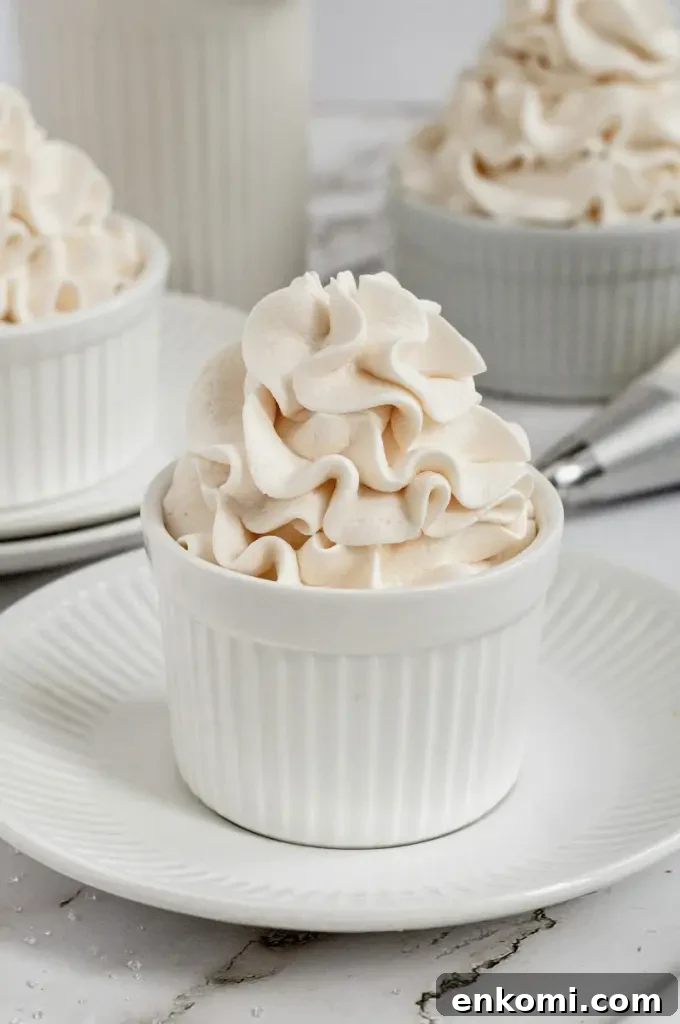 Dairy-Free Cream Cheese Frosting Recipe for Vegan Cakes 2 Fluffy dairy-free white cream cheese frosting swirled high in a white cup.