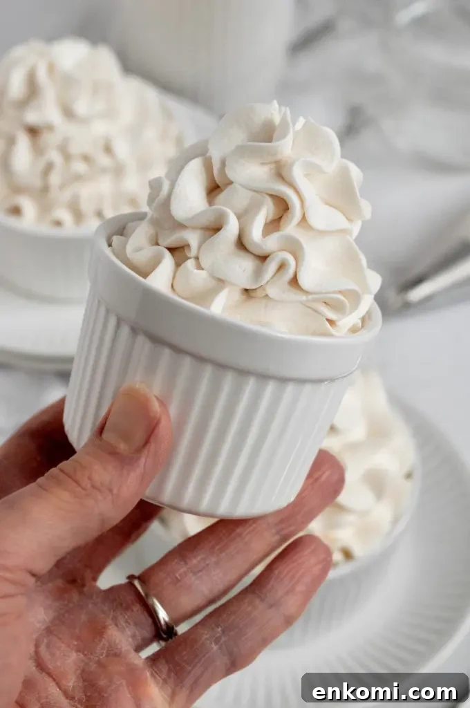 Dairy-Free Cream Cheese Frosting Recipe for Vegan Cakes 5 Fluffy dairy-free white cream cheese frosting swirled high in a white cup.