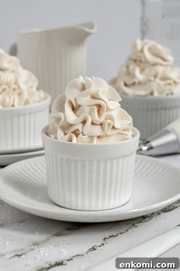 Dairy-Free Cream Cheese Frosting Recipe for Vegan Cakes 6 Fluffy dairy-free white cream cheese frosting swirled high in a white cup.
