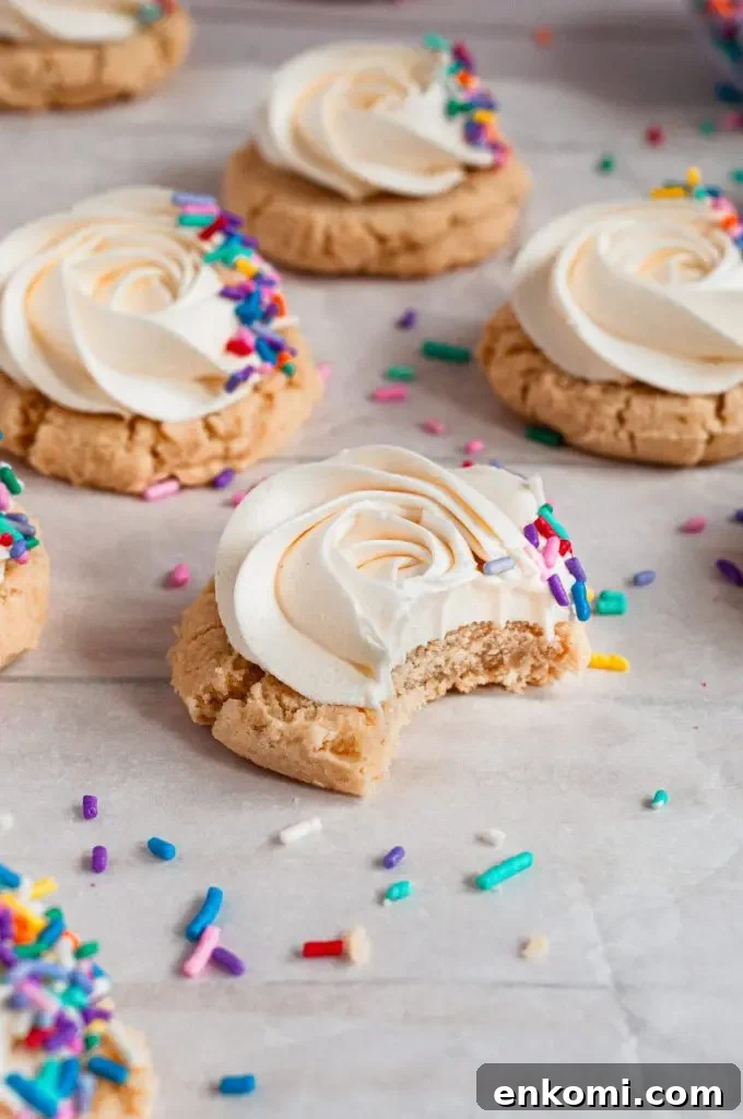 Dairy-Free Cream Cheese Frosting Recipe for Vegan Cakes 9 Soft golden yellow sugar cookies topped with a bright white frosting swirl and rainbow colored sprinkles.