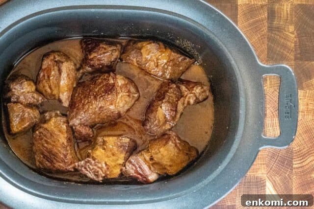Barbacoa prep: cooked chunks in the slow cooker, ready to shred.