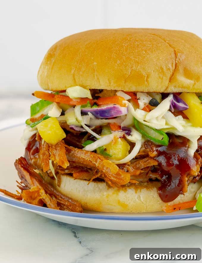 pineapple slaw on top of a pulled pork sandwich