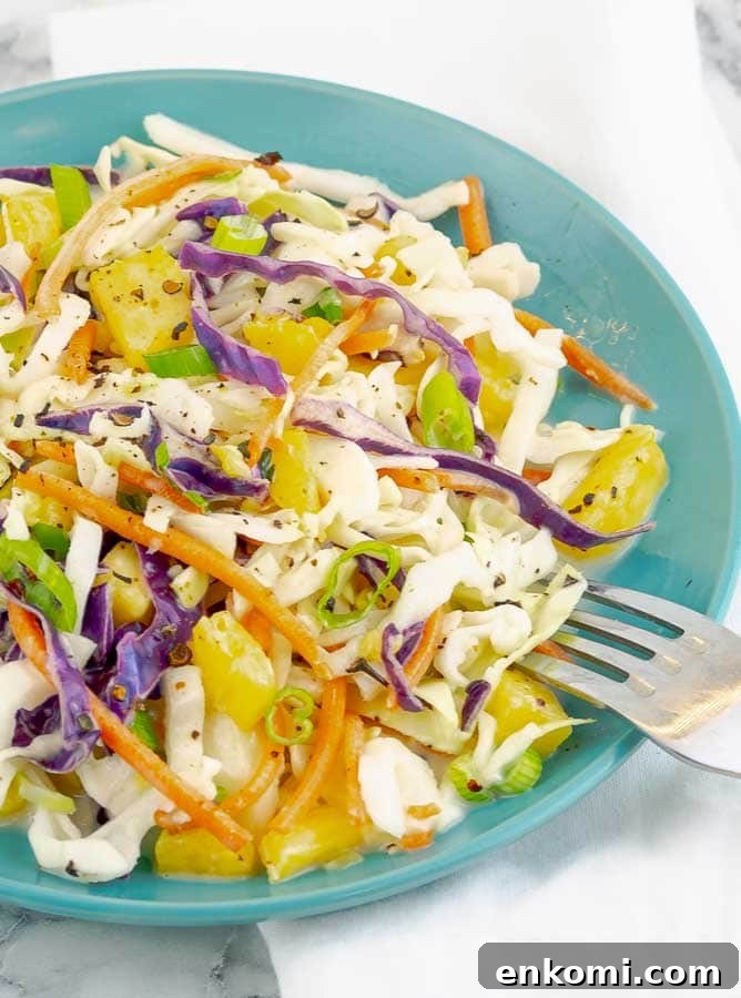 Easy Fresh Pineapple Slaw on a blue plate with fork
