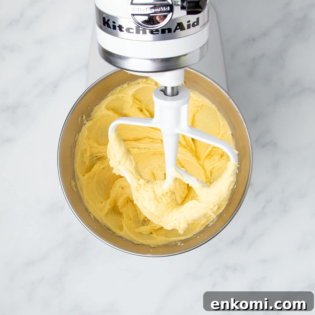 same bowl and paddle with darker yellow mixture after adding eggs