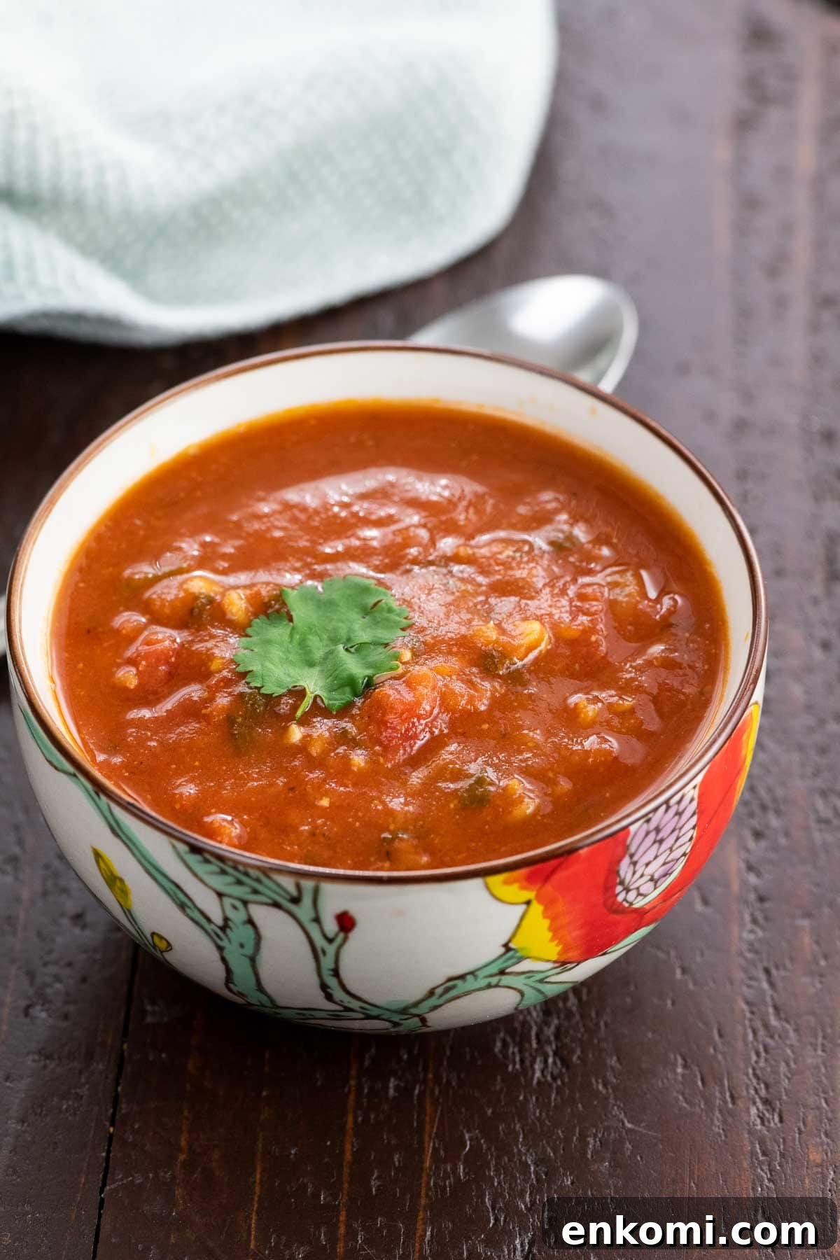 spiced tomato soup with red lentils in a bowl with a spoon and napkin