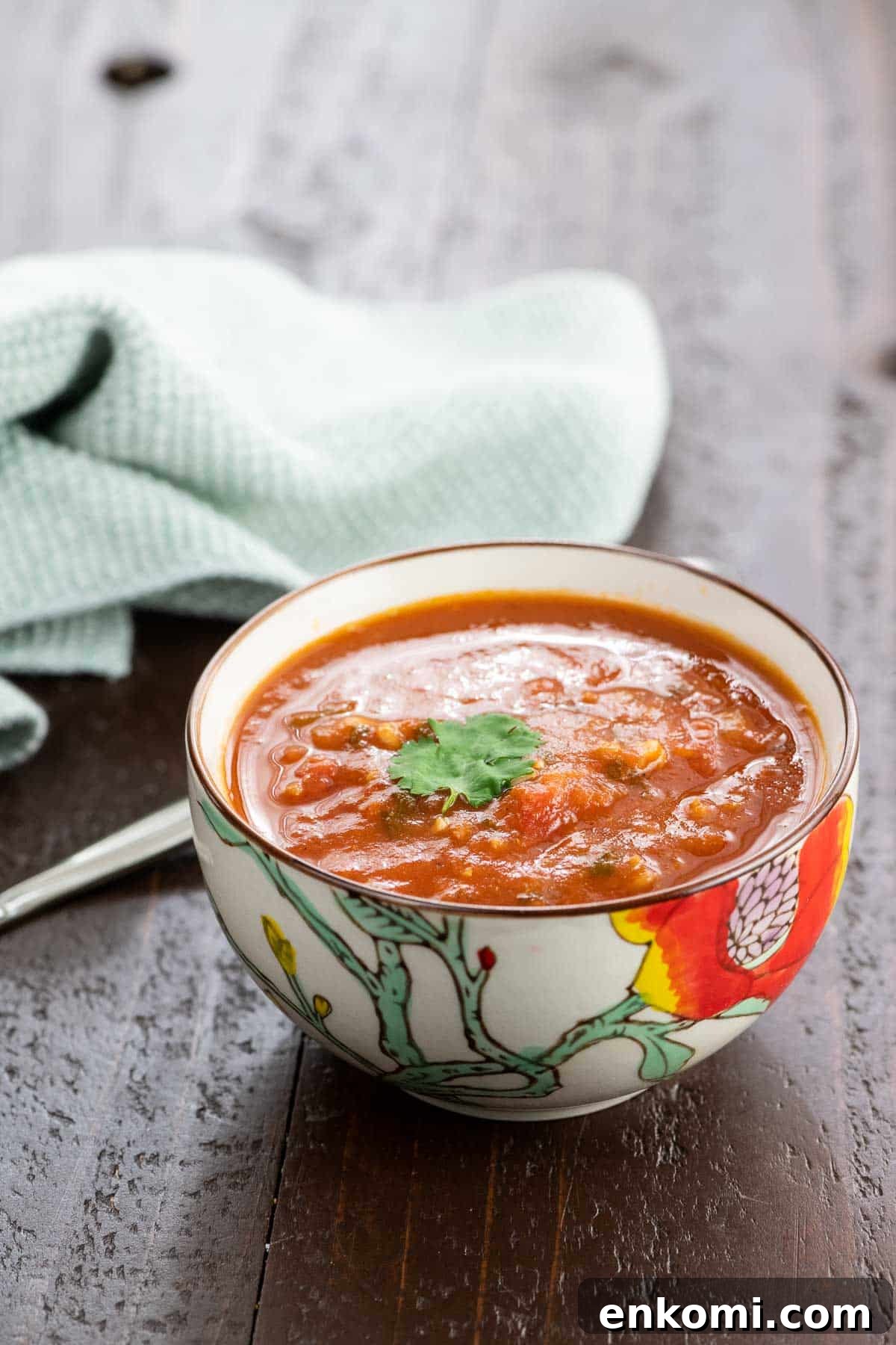 spiced tomato soup with red lentils in a bowl with a spoon and napkin