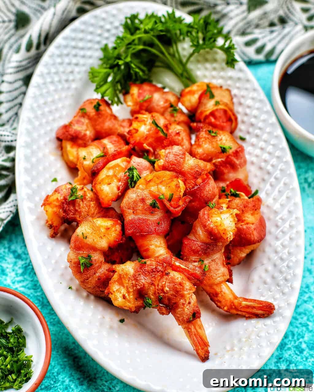 Crispy Air Fryer Bacon-Wrapped Shrimp Recipe 3 air fryer bacon wrapped shrimp on a white plate