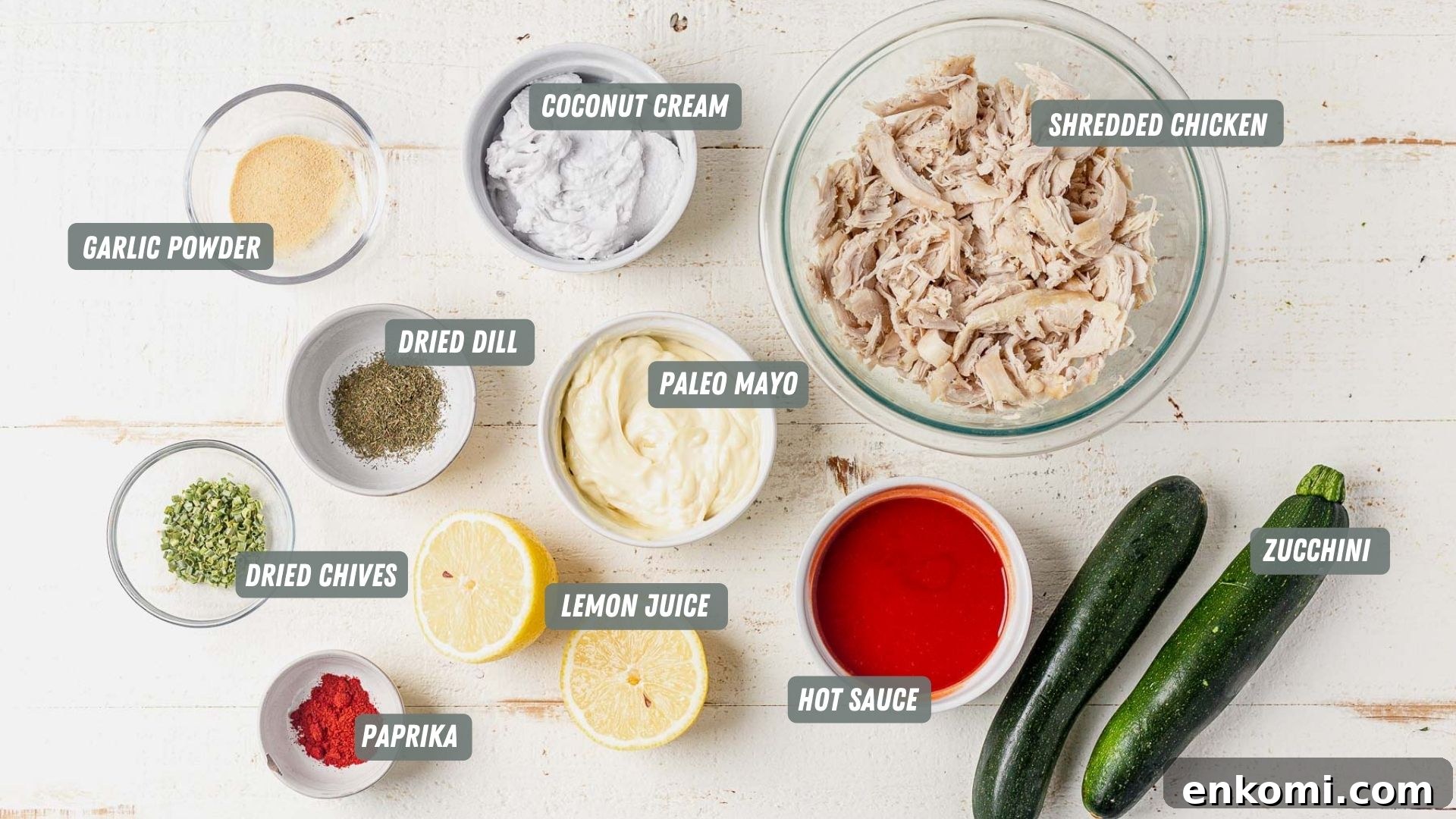 ingredients for buffalo chicken zucchini boats on a white table