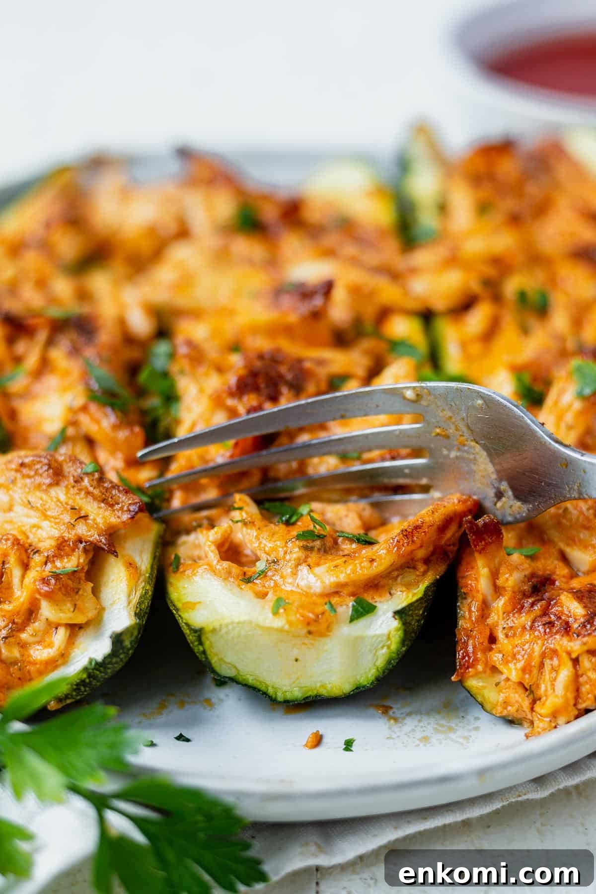 cutting into a zucchini boat filled with buffalo chicken