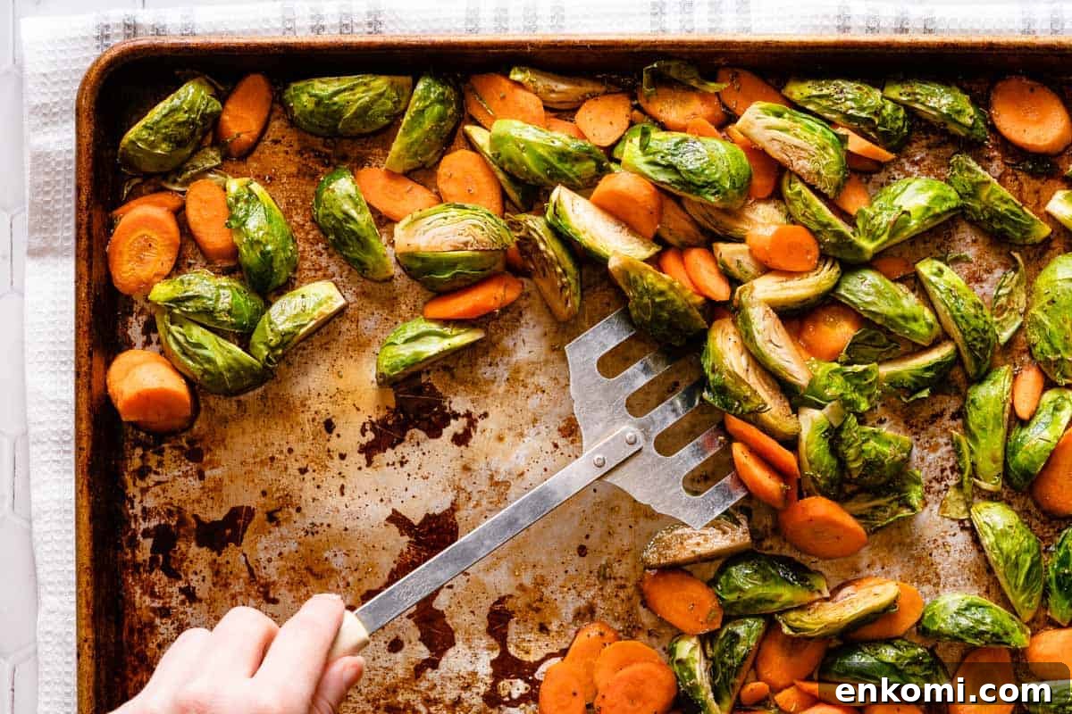 metal spatula scraping up vegetables on pan