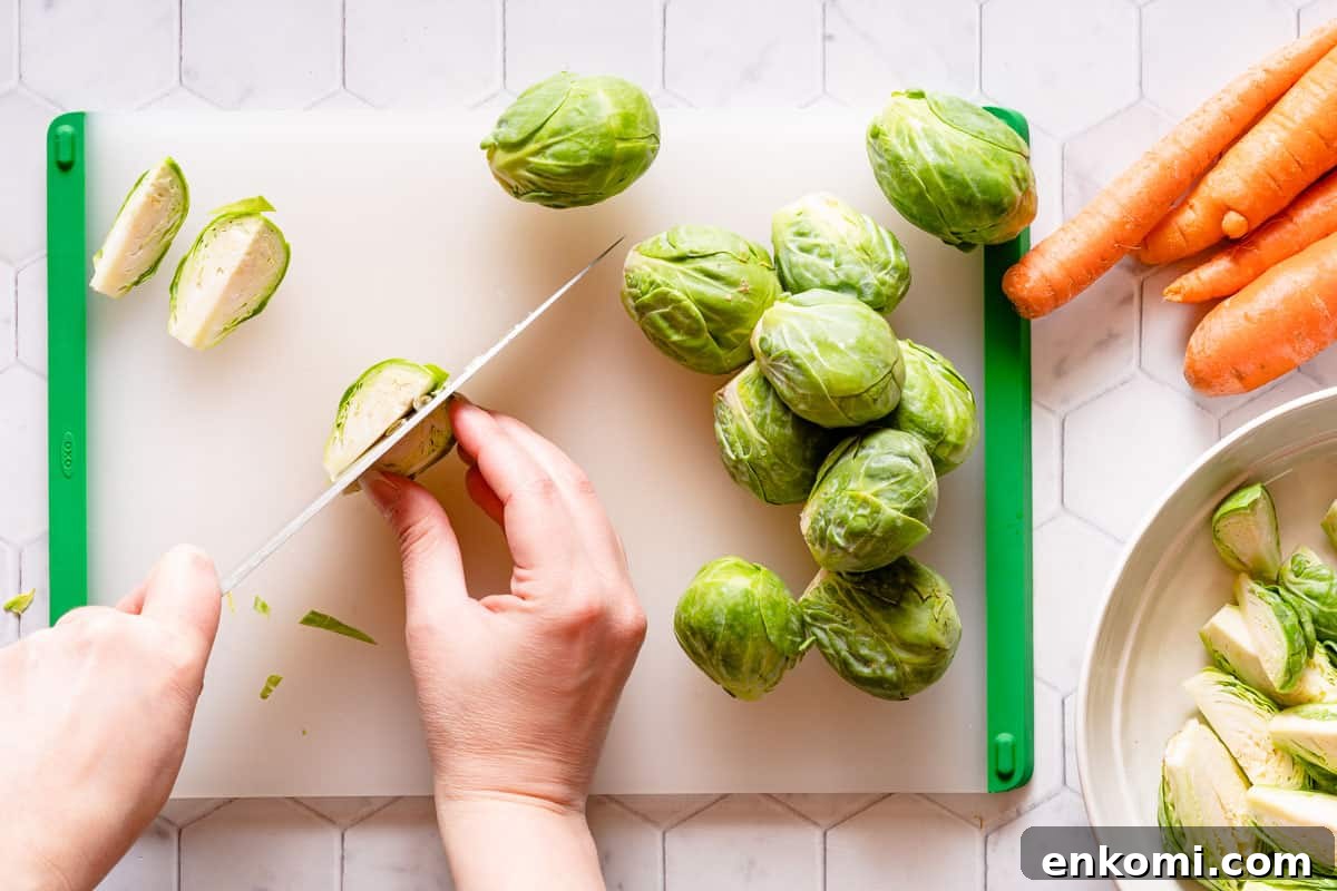 brussels sprout being cut into quarters on cutting board