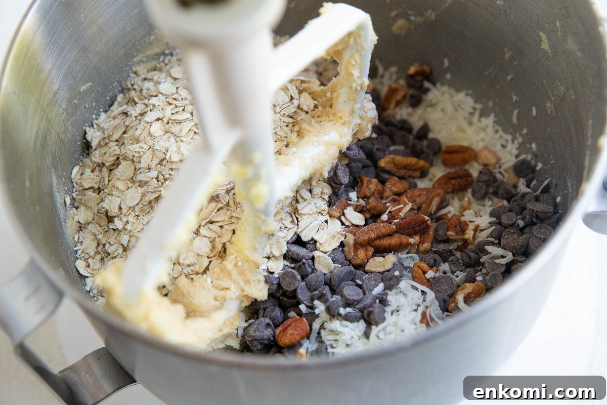 Oats, pecans, shredded coconut, and chocolate chips in a stand mixer
