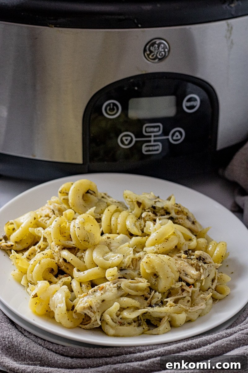 Slow Cooker Pesto Chicken Recipe for Tender, Flavorful Meals 5 twisted past in a pesto sauce with shredded chicken and melted mozzarella cheese
