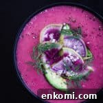 up close shot of finished vegan potato soup with avocado, radish and dil garnish.